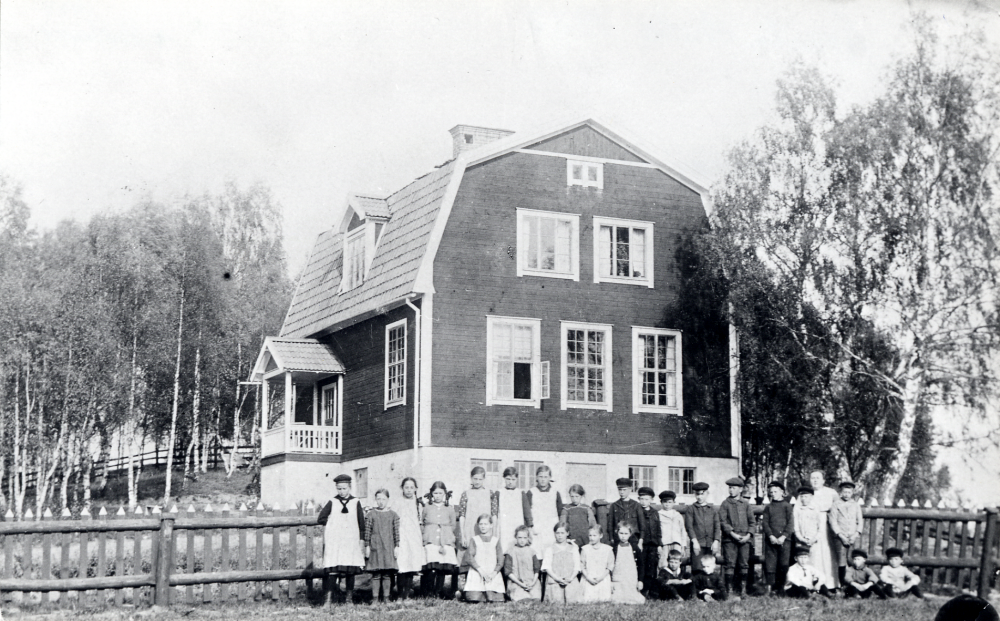 Lärarinnan  Signe Östman  tillsammans med skolbarnen utanför  Åvasta skola.  Bakre raden fr v   Maja Johansson   Anny Jansson   Margit Stolpe   Edit Larsson   Signe Hermansson   Ingeborg Lundblom   Karin Eriksson   Lisa Jansson  okänd,  Sten Hermansson  okänd,  Ejnar Johansson  okänd,  Harald Persson  okänd, lärarinnan Signe Östman och  Hugo Dahlberg.  Främre raden fr v: okänd,  Nelly Fröman  okänd, okänd, okänd,  Frans Stolpe  resten okända