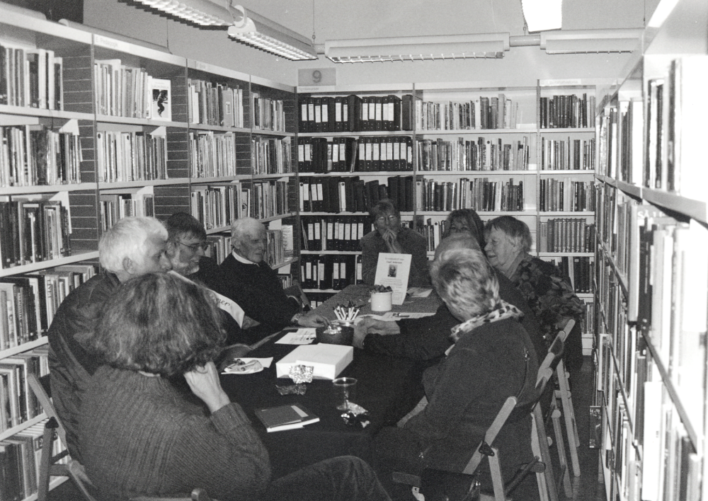 Bokfest 2003 med tema Berätta berätta - i toner, gester och ord! i samarbete med Vallentuna biblioteks vänner.  I hörnan med Berättarstafett sitter runt bordet fr v med ryggen mot kameran Lena Lundgren, okänd, Jan-Erik Forsberg, Gunnar Käller, Sylvia Pettersson, Eva Söderqvist, Linnea Nyman, skymd Gunhild Hillbo och Anne Spets