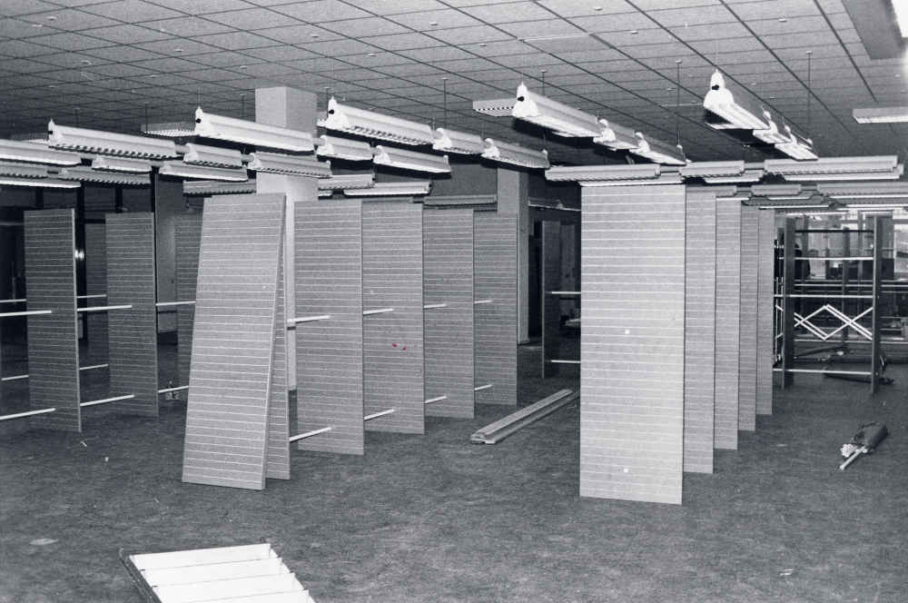 Vallentuna biblioteks nya lokaler i Tärningen inreds.  Här syns hyllorna där romaner och noveller skall vara.  Bakom hyllorna syns fönstren ut mot Tuna torg och Domus varuhus. Ännu återstår mycket arbete innan invigningen den 7 oktober