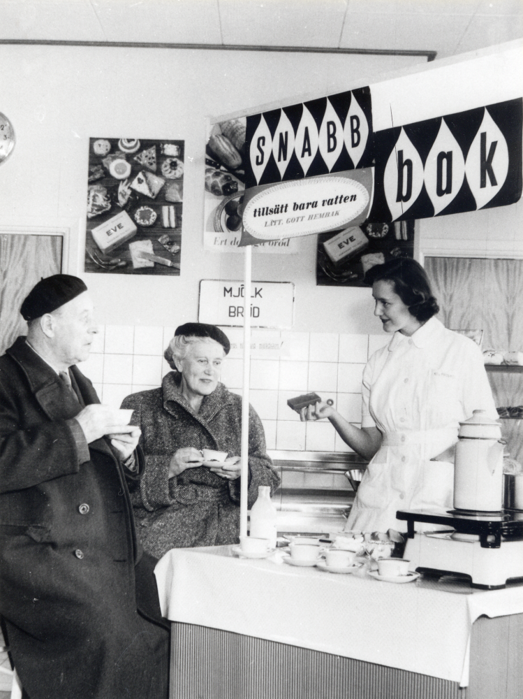 Ingrid Andersson  från KF:s provkök demonstrerar nya snabbaksmetoder i Konsumbutiken på Centralvägen i Vallentuna.  Volrat och Anna Fryckstedt provsmakar  
Se Konsum i norrort 1907-1997, en historisk krönika