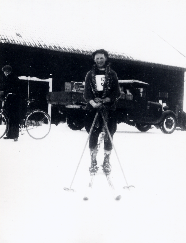 Skidtävling med mål vid Brottby handelsbod.  Segrare är Nils Alstermark i Brottby IF.  Framför magasinet står en gammal lastbil och en man med cykel