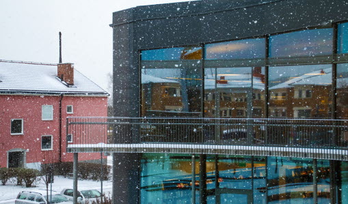Vallentuna Kulturhus från utsidan, entrén. Snöfall i förgrunden.