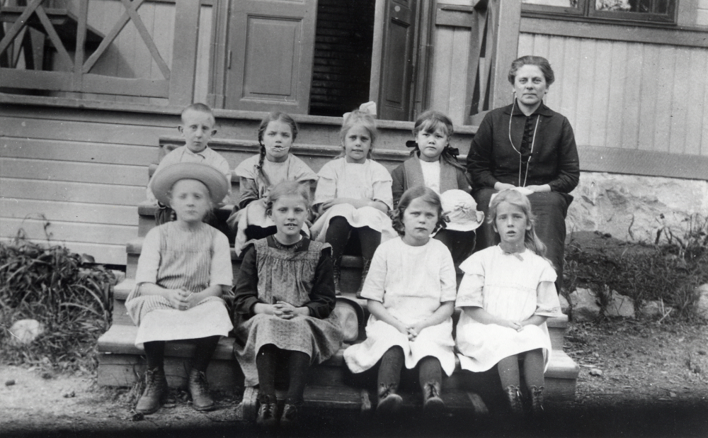 Lärarinnan Lisa Barthelsson tillsammans med skolbarnen utanför Sunnanå småskola.Nedre raden fr v Svea (eller Hedvig) Johansson, Gunvor Jansson, Gun Pettersson och Inga Thorell.  Övre raden fr v Sven Widegren, okänd, Dagny Thorell och Solveig Larsson.