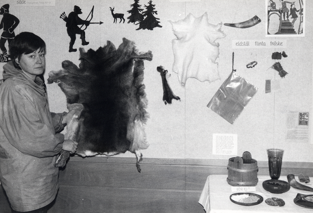Utställningen  Vardagsliv på vikingatiden  visades i  Vallentunasalen  1-29 februari 1984 . För fullständiga uppgifter se: 040 05 06: 008.  Marie Lenti  vid väggskärmen som presenterar jakt och fiske med redskap och beredda skinn