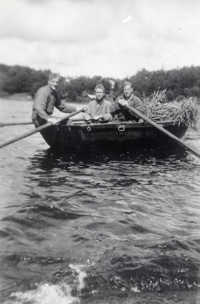 Ejnar Carlsson från Frösunda gjorde beredskapstjänst vid A1 i Stockholm. Man använde vass som foder till djuren under kriget.  Här sitter Ejnar Carlsson t h vid årorna i en båt full med vass. En speciell skördebindarbåt användes vid avverkningen av vassen. Se bild 100 01 00: 040