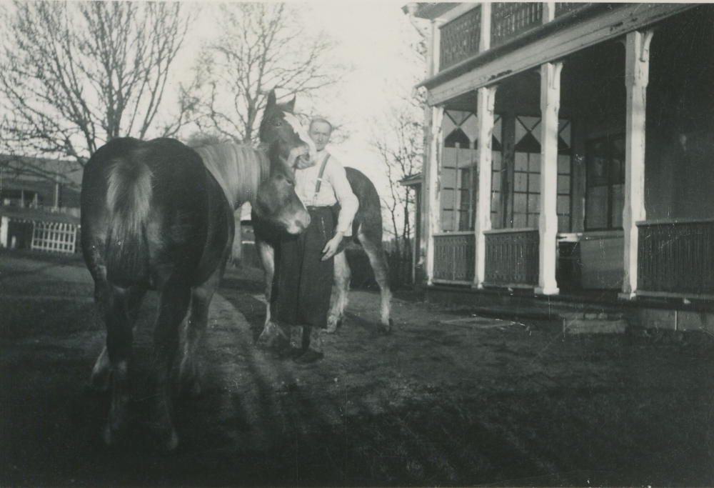 Drängen "Märstad" med två hästar vid entrén till Lilla Benhamra gård.