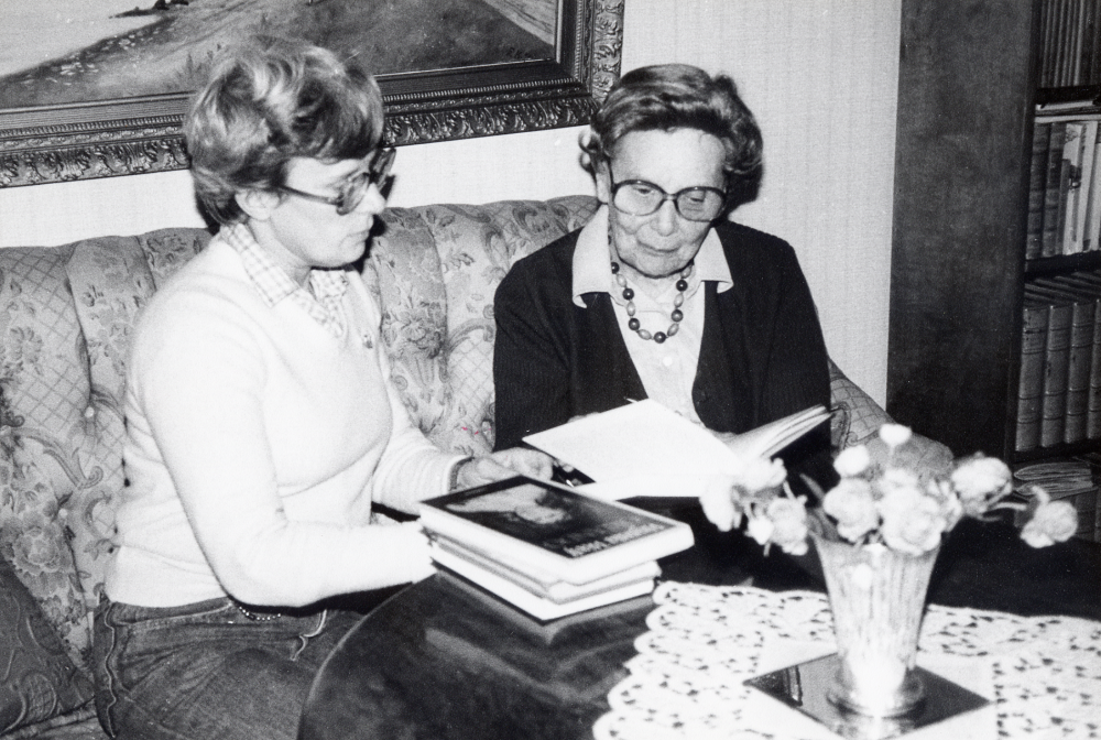 Tora Eriksson  t h får besök av Anna Brynell på Vallentuna bibliotek.  Tora Eriksson får hjälp av hemtjänstbiträdet Louise Nilsen, som hjälper till att välja ut en bok. Bibliotektes verksamhet med boklån till den som inte själv kan komma till bilblioteket är Boken kommer