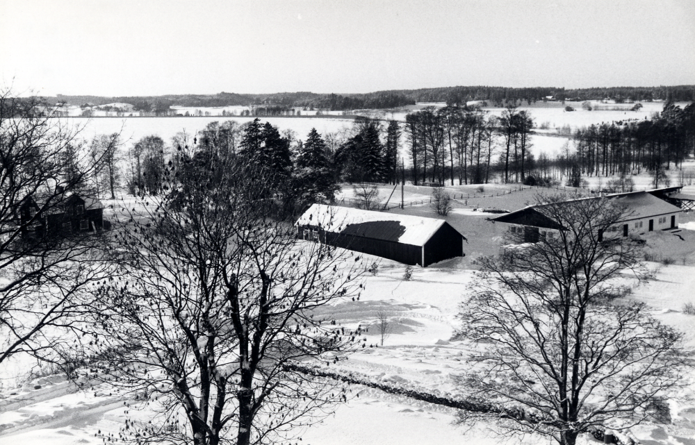 Utsikt mot sydväst från Vallentuna kyrktorn. Tv syns Sjövillan och i mitten ekonomibyggnader till Vallentuna prästgård. I bakgrunden den isbelagda Vallentunasjön
