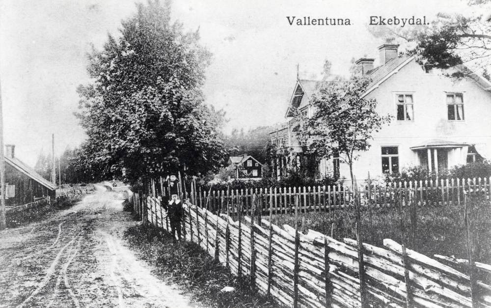Utanför  Ekebydals handelsbod  står t h  Sven Österberg  son till handlaren  Conrad Österberg.   Ev är pojken på staketet Svens lekkamrat  Tom Nyström  från Mötet.