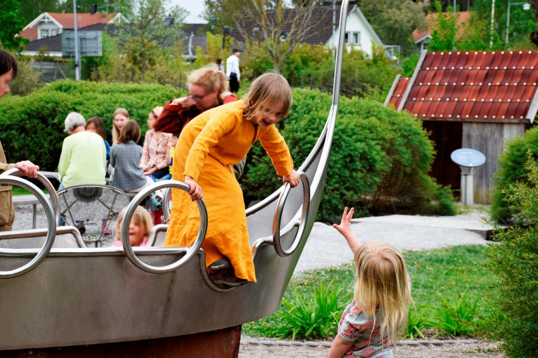 barn leker i ett litet vikingaskepp
