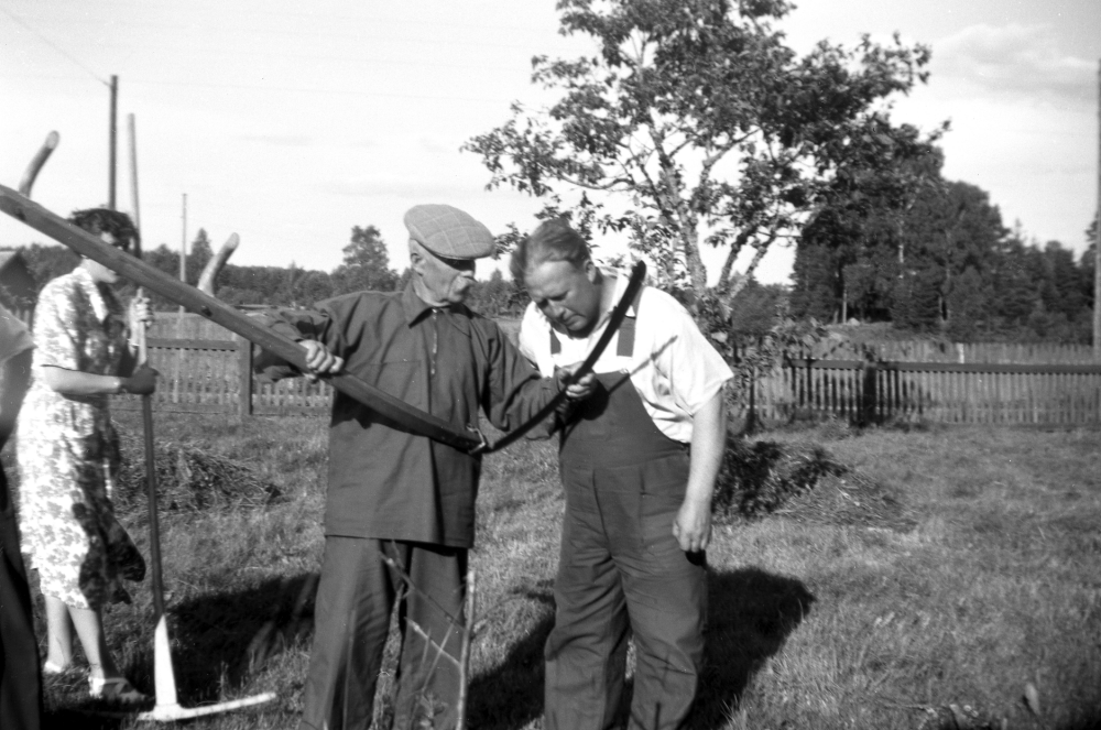 Gösta Karlsson driver gården Karlso. Fastigheten ligger vid infarten till Molnbyvägen från Lindholmsvägen och är nu riven.  En del ekonomibyggnader finns fortfarande kvar.  Gösta Karlsson och hans hustru Greta driver den lilla gården och odlar för eget bruk.  Greta står med räfsan t v, medan Carl Johan Pettersson, Brännar-Pelle, från Sigridslund i Ormsta och Gösta Karlsson synar lien.  Brännar-Pelles barnbarn Harriet och hennes familj hyrde övervåningen i Karlso 1950 till 1955.