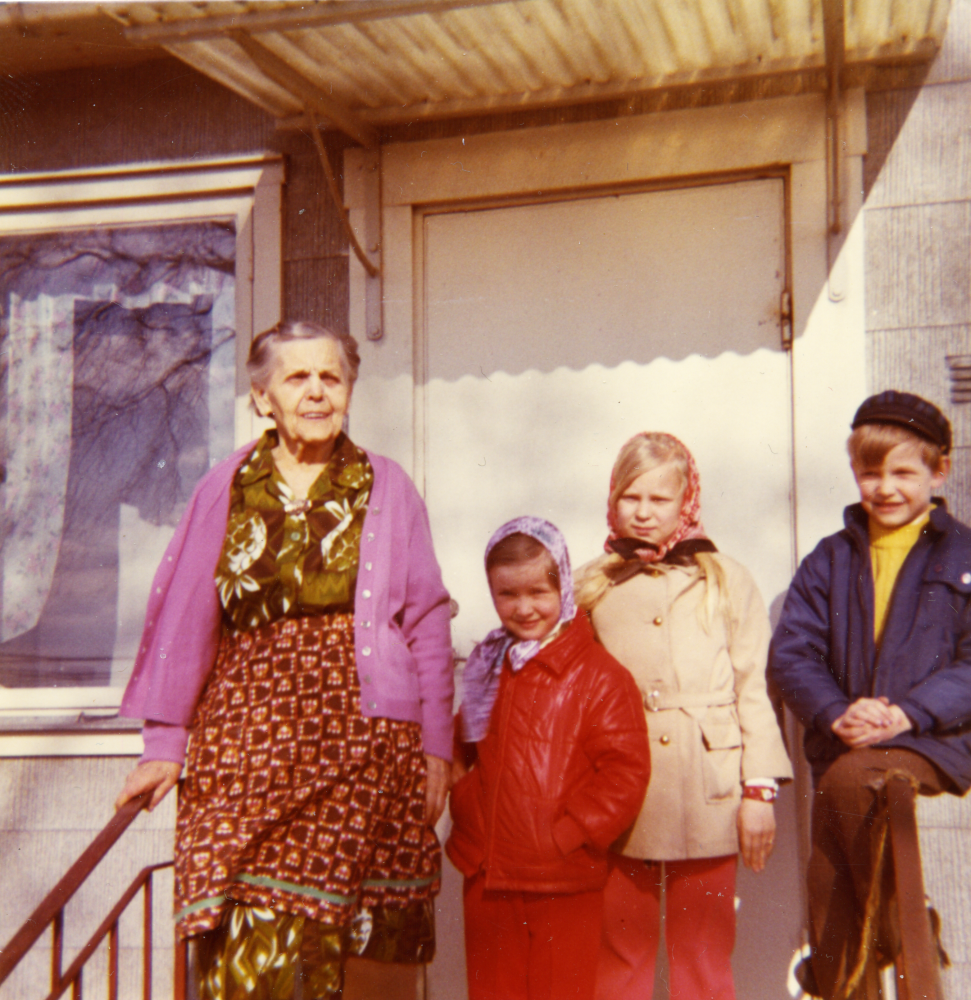 Astrid Charlotta Andersson står med sina barnbarn på trappan till sitt och maken Carl-Henriks hus på Lingsbergsvägen. Original och uppgifter: Nolle Andersson, son till Astrid och Carl-Henrik.