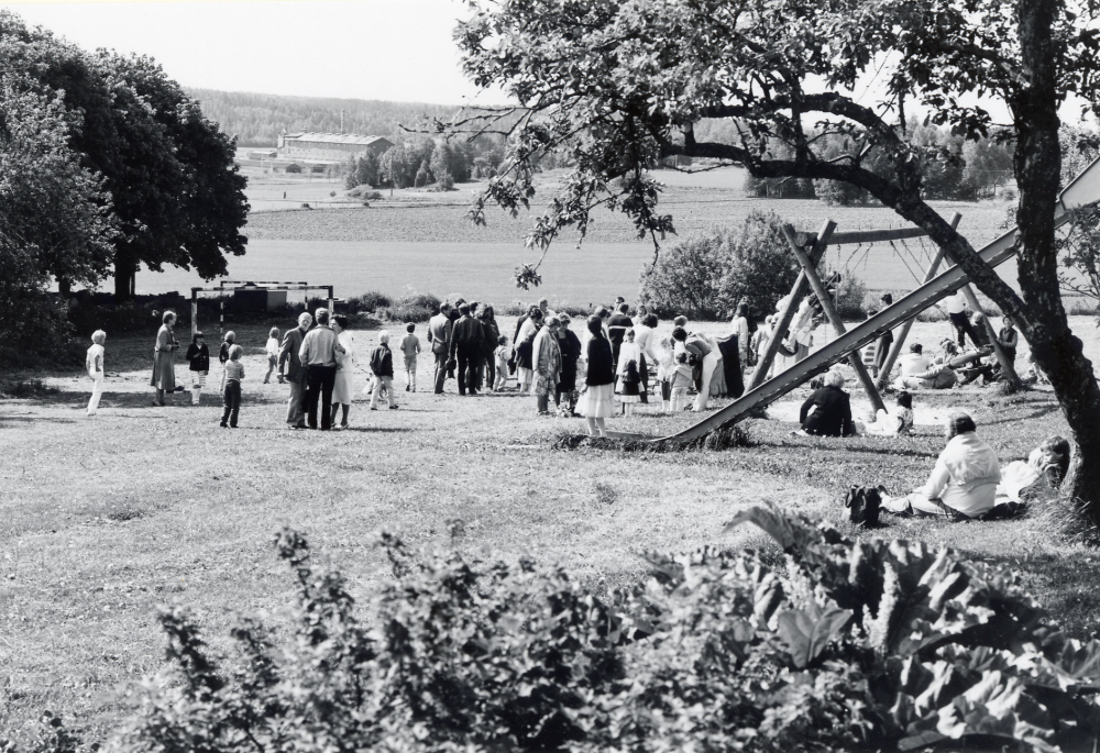 Sista skolavslutningen i Kårsta kyrkskola efter vårterminen 1982.  Fr o m höstterminen 1982 flyttar barnen i  den nya Kårstaskolan vid Bergsjö- vägen.  Efter examen i Kårsta kyrka samlas lärare och skolbarn med familjer på skolgården .  Långt borta i bakgrunden skymtar Broby tegelbruk