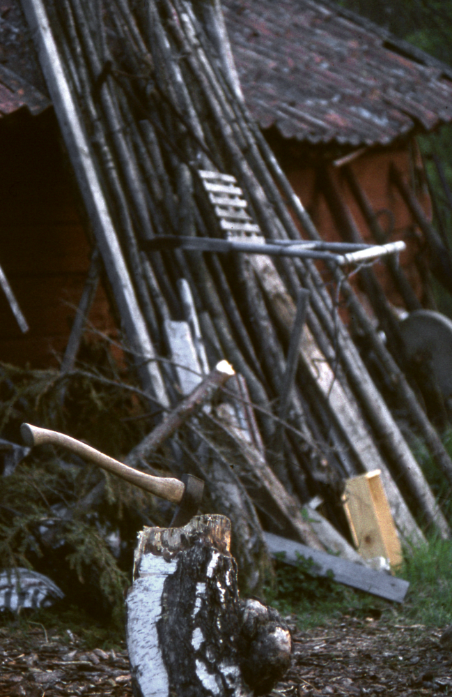 Yxa och huggkubbe vid Norrtorp. En gammal spark står lutad mot ladan. Fotografiet ingår i bildserien Några torp i Vallentuna 1970 som köptes av Vallentuna kommun. Dokumentationen gjordes mot bakgrund av den snabba förvandling av kulturlandskapet som skett och ännu sker. Många torp anlades under den svenska landsbygdens folkökning under slutet av 1700-talet och decennierna framöver. Dessa torp och små gårdar försvinner alltmer då de inte längre är lönsamma. Kulturmiljö.