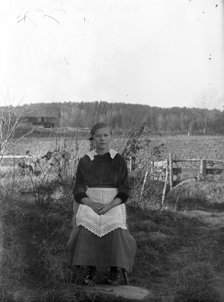Flicka på stol. Platsen är okänd. Uppgift om fotoår saknas, men troligen 1920-talet.