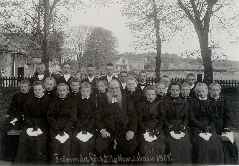 Frösunda församlings nattvardsbarn och kyrkoherde Carl Mauritz Anjou, efter konfirmation i Frösunda kyrka. Namn på barnen saknas. På fotokartongen står skrivet: "Eva Jansson f 1880-tal (?), Evas läskamrater". I bakgrunden syns Frösunda kyrkskola och Frösunda kyrka samt t v Prästgårdens ekonomibyggnader.
Samma bild som 1145.