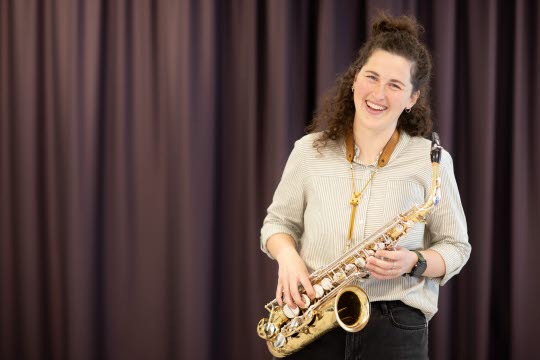 Porträtt av  Amelie med saxofon i handen