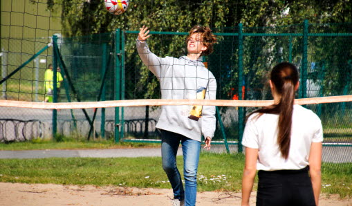En pojke och en flicka som spelar volleyboll
