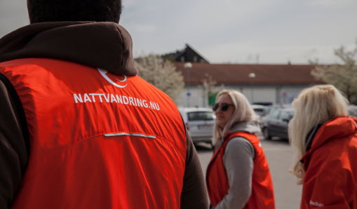 Fyra nattvandrande vuxna med röda västar..