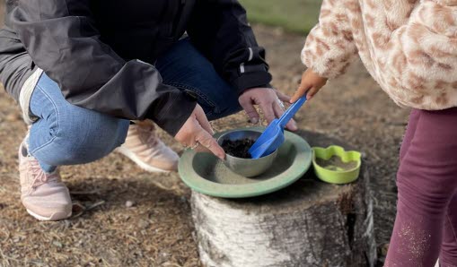 Barn gräver i sandlåda