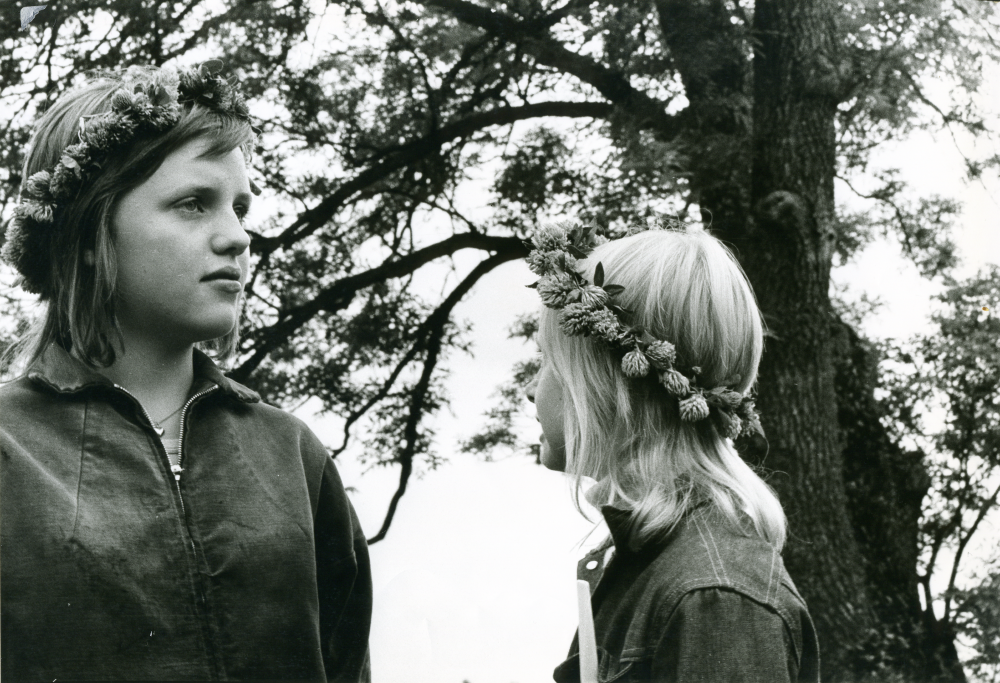 Traditionsenligt midsommarfirande på Kyrkängen i Vallentuna. Två flickor med blomsterkransar i håret.
•Fotografiet ingår i bildserien ”Vardagsliv i Vallentuna kommun” av Rachael Gough-Azmier & Gunilla Blomé, Haga Studios HB.