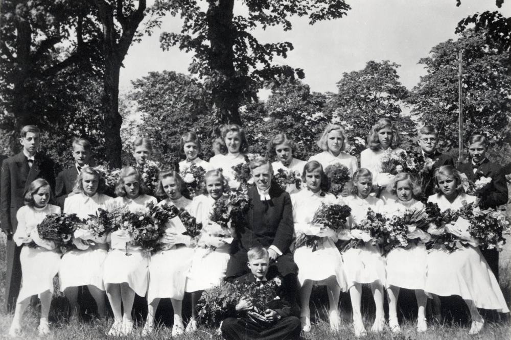 Kyrkoherde Sven Vängby  bland konfirmanderna efter konfirmation i Vallentuna kyrka.  Första raden fr v Maj-Britt Tillborg,  Sven Vängby, Gullan Hedlund (född 1929), Viola Lindersson, Dagny Vallsten?,  Siv Gustavsson.  Sittande framför Einar Gustavsson Hassla.  Bakre raden nr 5 Eriland Eriksson dotter Siv? nr 6 Gerd Österberg? Uppgifter från Siv Jonsson.

Andra flickan från höger i bakre raden är Gudrun Larsson född 1930 gift Söderlund. Uppgift från Gudruns dotter Christina.

Uppgift om fotoår saknas, men troligen mitten av 1940-talet.