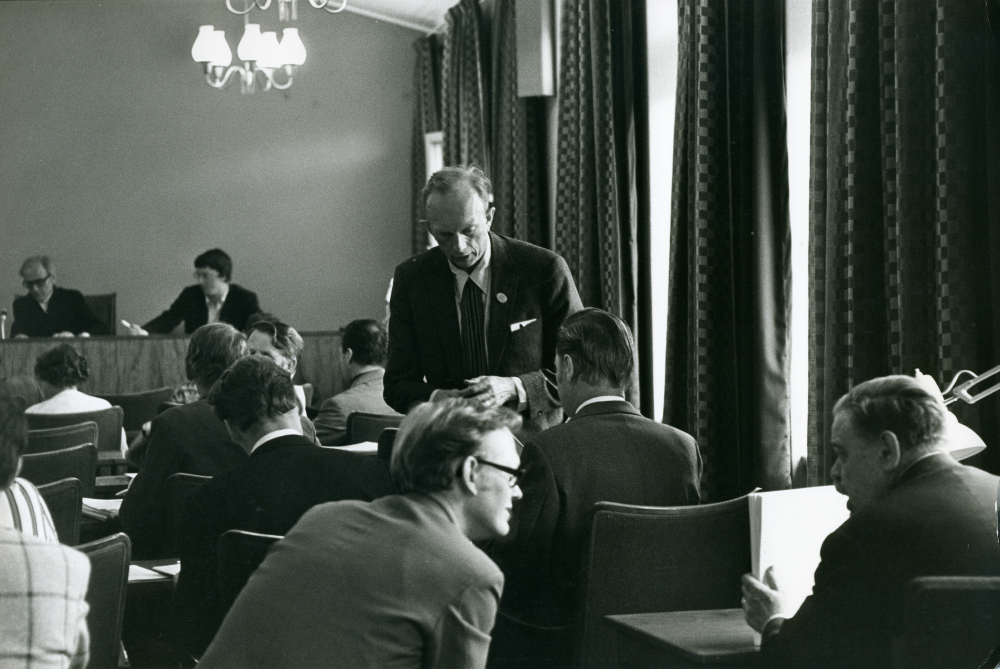 Fullmäktigesammanträde den 21 juni 1972. Det är sista fullmäktigemötet före sommaruppehållet och bland annat står byggnadsfrågor på agendan. Mitt i bild Åke T Carlestam (M).
•Fotografiet ingår i bildserien ”Vardagsliv i Vallentuna kommun” av Rachael Gough-Azmier & Gunilla Blomé, Haga Studios HB.
