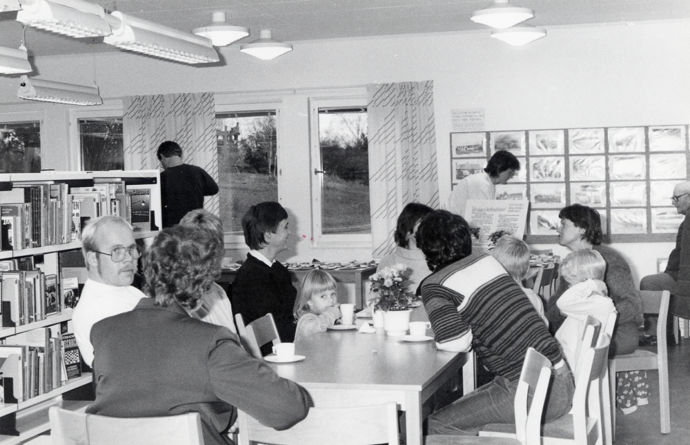 Öppet hus i Lindholmens bibliotek, där låntagarna bl a bjöds på kaffe och saft med dopp.  I bakgrunden presenterar Vallentuna bildarkiv fotografier med motiv från Orkesta
