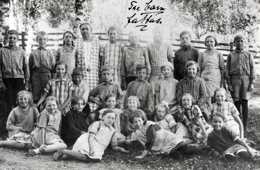 Lärarinnan Signe Östman tillsammans med skolbarnen utanför Åvasta skola.  Övre raden fr v Lars Ekberg, Stig Öhman, Karin Mattsson, Signe Östman, Stella Öhman, Erik Ekberg, Inga-Lisa Gustavsson, Gunnar Laurell, Gunvor Laurell och Henry Jansson. Knästående mellanraden fr v Stina Öberg, Arne Östervall, Sven Johansson-Billersjö, Tage Mattsson, Rut Gustavsson och Svea Johansson.  Sittande fr v Birgit Roos, Märta Nilsson, Elin Johansson, Maria Jansson, Ulla Ekberg, Anna-Lisa Vadström, Karin Karlsson, Lilly Nyberg, Birgit Grandin, Gertrud Johansson och Majsy Larsson