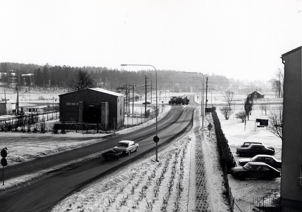Utsikt mot söder från skolkontorets fönster i Tunahuset. T v ligger Roslagsbanan, i förgrundens mitt Banvägen som på andra sidan korsningen övergår i Stockholmsvägen och t h Upplands Väsby-vägen. Gaveln t h tillhör bostadshuset på Centralvägen