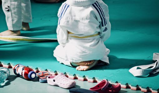 barn sittandes i judodräkt 