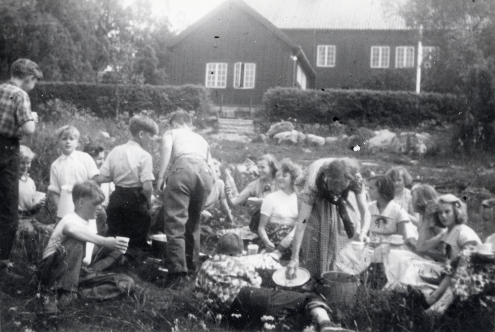 Lärarinnan Kerstin Lundkvist har saftkalas tillsammans med skolbarnen utanför Hjälmsta skola I bakgrunden Röda skolan
