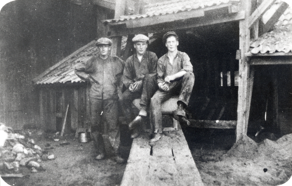 Åby tegelbruk.  Vid skottkärran står tegelmästare Harry Skogberg.  På kärran sitter Max Karlsson och Sven Nordström