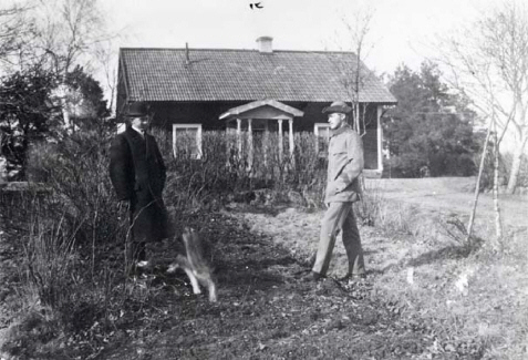 Två män som står framför ett hus