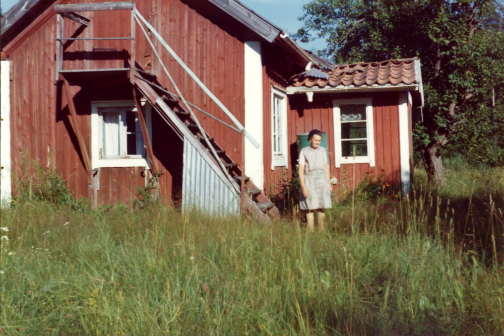 Dalkarlshagen i Össeby-Garn.  Vid huset står Maria Borg, som bodde i huset 1913-1918