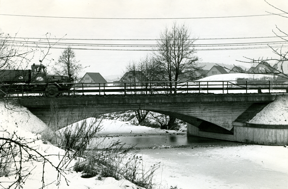 Bakom bron över Husaån skymtar bostadsområdet Sundby.