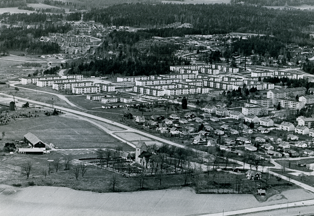 Vallentuna kyrka ligger i mitten av bildens nedre del. I mitten av bilden syns Väsbygården, Sörgården och Norrgården. Bostadsområdet Rosendal syns i övre vänstra hörnet.