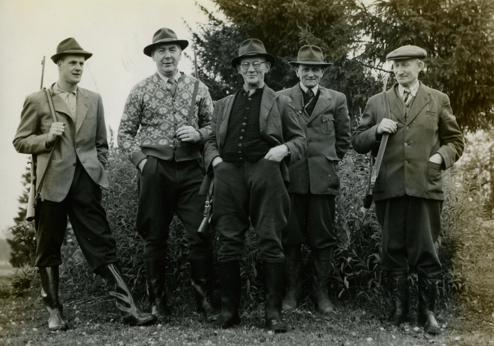 Jaktlaget "Spårvägarna" arrenderade jaktmark från Orkesta Lundby gård. Jägarna från  "Spårvägarna" arbetade alla på Stockholms Spårvägars vagnhall vid Sundbybergsgränsen.  Här är jaktlaget uppställda vid jaktstugan i Stolp-Ekeby för att förbereda älgjakten.  Man jagade mest älg, men öven rådjur, hare och fågel.  Fr v Lennart Jansson, Knut Wall, Gunnar Jacobsson, Eskil Lundell (ägde Norrgården i Orkesta Lundby och dog 103 år gammal)) och Hilding Ekerholm