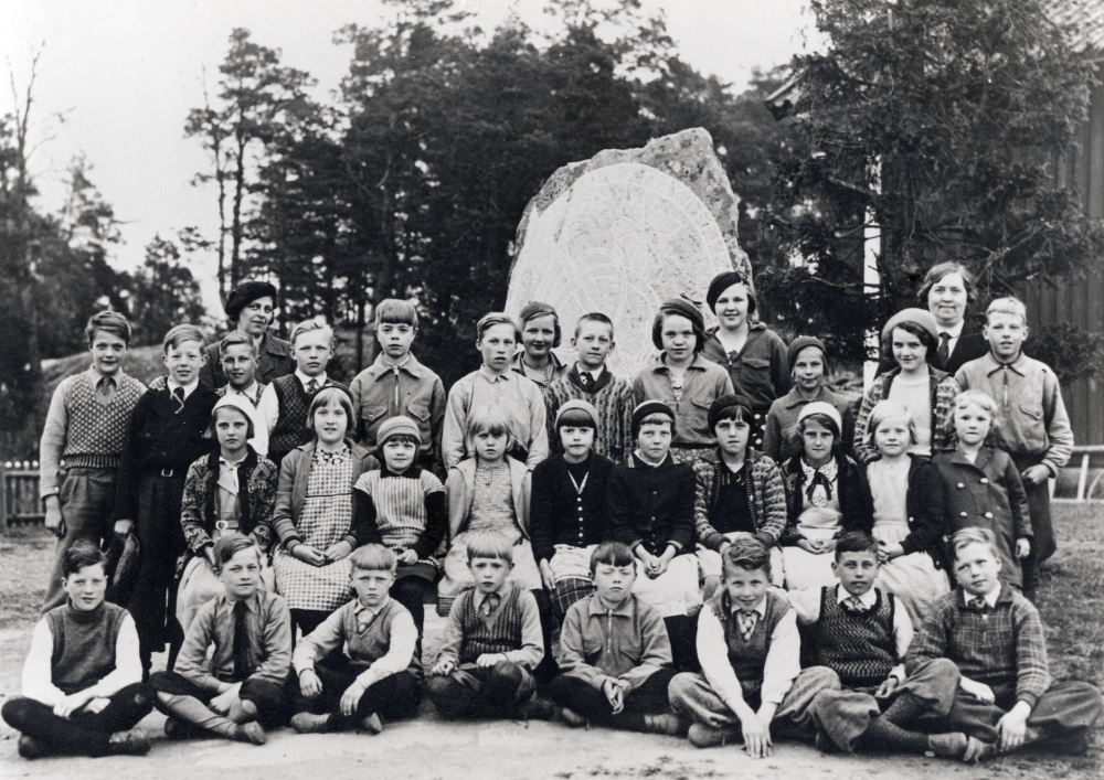 Stångberga skola. Raden längst bak fr v lärarinnan Rut Nilsson-Eriksson, Svea Söderman, okänd  och småskollärarinnan Lydia Sjöstedt-Persson. Rad 2 stående fr v Karl-Erik Eriksson, Gösta Lindberg, Martin Eriksson, Bengt Hessler, Stig Karlsson, Axel Schröder, Gunnar Ramström, Eva Boström-Andersson, Eva Karlsson, Viola Eriksson-Eklund och Harry Forsman.  Rad 3 sittande fr v: Inga Eriksson-Karlsson, Hildur Andersson-Kumelius, Marianne Ramström, Lilly Pettersson, Asta Karlsson-Pettersson, Harriet Karlsson, Gunvor Eriksson-Frisk, Aina Eriksson-Orebrandt, Eivor Jakobsson och Margit Wikland.  Rad 4 sittande på marken fr v: Bertil Eriksson,  Karl-Erik Ramström, Ture "Tusse" Eriksson, Bertil Lövgren, Olle Boström, Sigge Lunddal, Sven Johansson och Karl-Erik Karlsson-Värmel