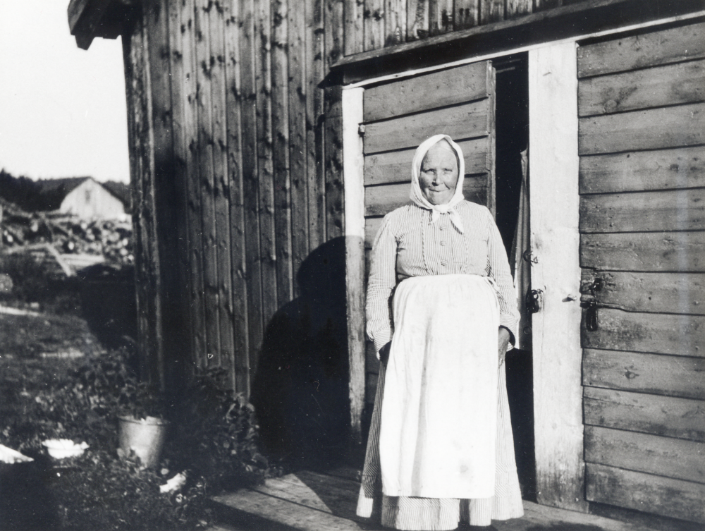 Ingeborg Jansson  levde 1850-1937  och bodde i drängstugan vid Ösby efter sin 50-årsdag.  Där bodde hon till 1927 då stugan revs då hon flyttade till en tillbyggnad på tvättstugan.  Hon blev tidigt änka då hon bodde på torpet Spånlöt som hörde till Lövhamra gård, där hon gjorde dagsverken.  Hon gick sedan runt i gårdarna och hjälpte till med allehanda sysslor, t ex tvätt.  Varje söndag gick hon i kyrkan.  I bakgrunden skymtar Lilla Ösby