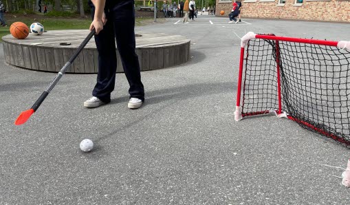 Elev spelar innebandy på skolgården