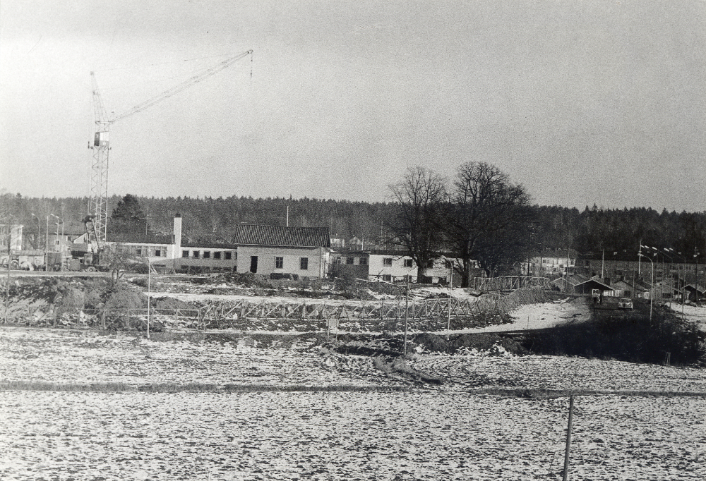 Ålderdomshemmet Väsbygården byggs.  Tv skymtar bostadshusen i Sörgården.  Väsby gårds östra flygelbyggnad finns ännu kvar.  Huvudbyggnaden och västra flygeln är rivna