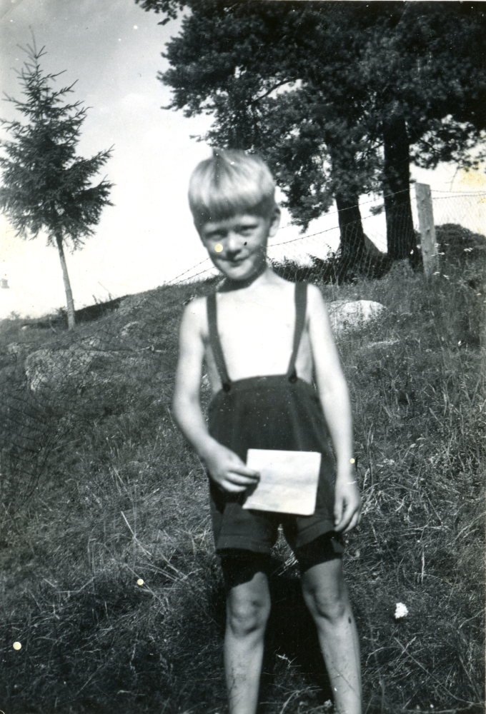 Lars Bornholm vid Korsbacken. Bilden är tagen ovanför badplatsen som låg i den lilla viken med den stora stenen nordväst om den dåvarande bryggan som prästgårdsarrendatorn nyttjade i anslutning till arrendatorbostaden. Fundament av den sistnämnda finns delvis kvar, (2016). Bilden tagen 1947.