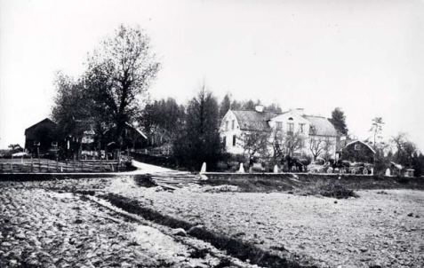 Åker med ett hus i bakgrunden