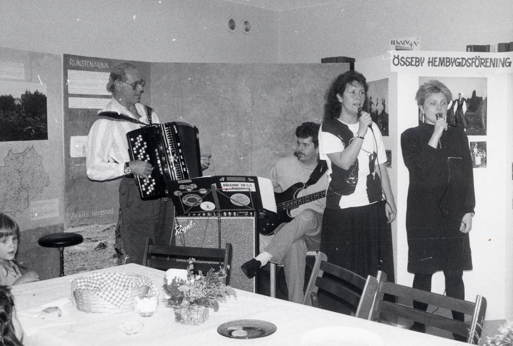 Öppet hus  på  biblioteket i Karby  med bl a  utställningar  och  musik  i hyresgästlokalen utanför biblioteket. Delar av  Össebyamatörerna  uppträder. Fr v  Pelle Andersson   dragspel   Sven Andersson   elgitarr       Lisa Blomdin  och  Anki Gustavsson   sång  Den lilla flickan t v är  Elin Andersson