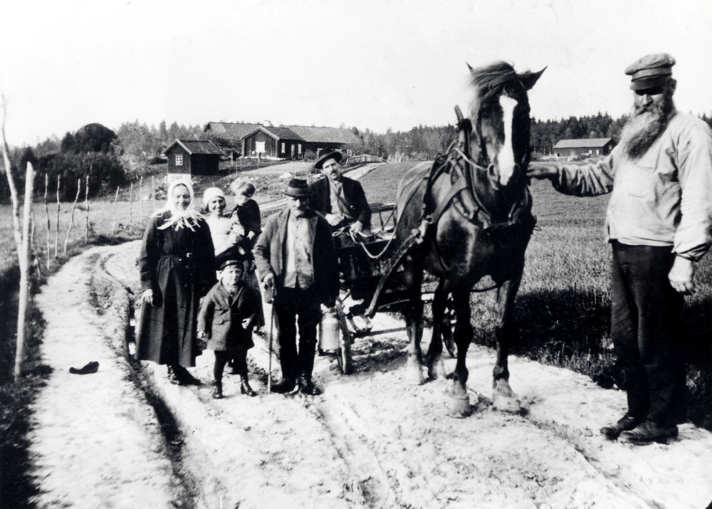 Sättra torp i Kårsta.  Fjärdingsman, backatorparen, August Ländin håller i hästen Bläsan.  Bakom hans arm syns uthusen vid Backatorp. Vid tömmarna i vagnen sitter den sista sättratorparen Evert Gunnar Klaar, född 1902. Det äldre paret är mormor och morfar Emma och Gustav Eriksson från Frösunda.  Bakom dem står torparmor Märta Sofia Klaar, född 1903, med sonen Lennart, född 1927, på armen.  Han minns fortfarande tillfället då fotografiet togs och var mycket olycklig över att han tappat sin mössa.  Den ligger på marken t v.  Äldsta sonen Rune Klaar, född 1924 står mellan sin mormor och morfar.
