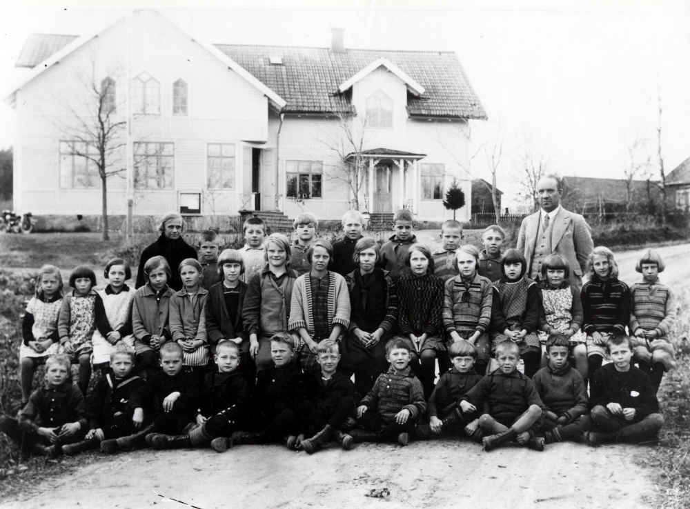Lärarna Olga Pettersson och Brynolf Fromm tillsammans med skolbarnen utanför Vada skola, byggd 1905. Första raden nedifrån fr v Nils Sjöberg Snarsättra, ev Roine Bjurström ELLER Ernst Engström, ev David Thun Skrikboda, ev Hans ? Bergsättra, Seved Eriksson Smedstorp, Stig Andersson Målsta, Kalle Åkerblom Vadaby, Sven Johansson Klingsboda, Åke Karlsson Rosendal, Harry Jansson Nybygget, Sture Karlsson, Rosendal. Rad 2: Axelina Andersson Målsta, Märta Karlsson Rosendal, Gunvor Andersson Skesta, Ingegerd Singfeldt Vada prästgård, Wiwi Wallin Lugnet ev Målsta, Maj Hoffman Lussinge, Eva Möller Husa, Siri Landén Fiskartorp, Ingegerd Åkerblom Vadaby, Ella Eriksson Sandbacken, Märtha Eriksson Smedstorp, ev Maj-Lis Johansson Vadatorp, Maj-Britt Johansson Vadatorp, Gretchen Engström Seneby, Harriet Bjurström Benhamra. Rad 3: Karl-Erik Thun Skrikboda, ev Helge Andersson Benhamra, Kalle Möller Husa, Simon Eriksson Smedstorp, Harry Thun Skrikboda, Anders Thun Skrikboda och Ruben Bevner Nybygget. Olga Pettersson undervisade i klasserna 1-2 och Brynolf Fromm ansvarade för klasserna 3-6 samt fortsättningsskola varje vinterlov om sex veckor