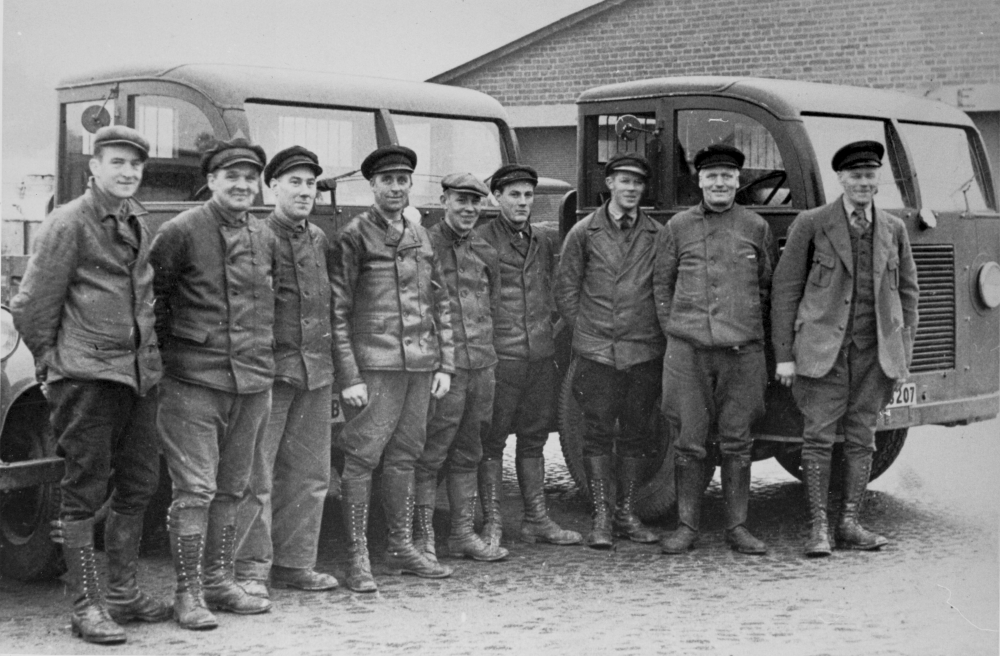 Anställda vid Roslagsbanans lastbilsstation står uppställda. Från vänster Nisse Andersson, Martin Karlsson, Ernst Folkesson, Nisse Nord, Holger Karlsson,Hilding Lundgren, Lennart Andersson, Gustav Andersson, basen och tidigare ägaren av åkerirörelsen Helge Andersson. Jämför bild 128.
Original från Lunda hembygdsförening