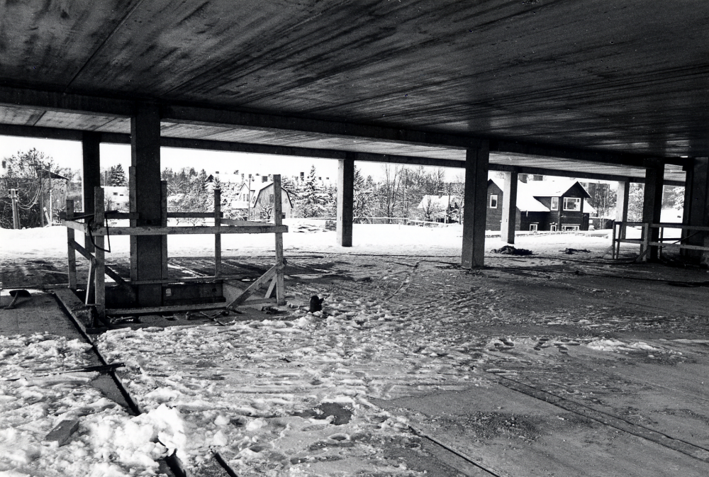 Utsikt  från våning två i det ännu ej färdiga förvaltningshuset  Tärningen  mot begyggelsen längs  Mörbyvägen  Det mörka huset mellan pelarna är en av  tvillingvillorna  den andra villan revs inför byggstarten av Tärningen.  Från hösten 1982 har socialkontoret och Försäkringskassan sina kontor på detta nu snöhöljda våningsplan