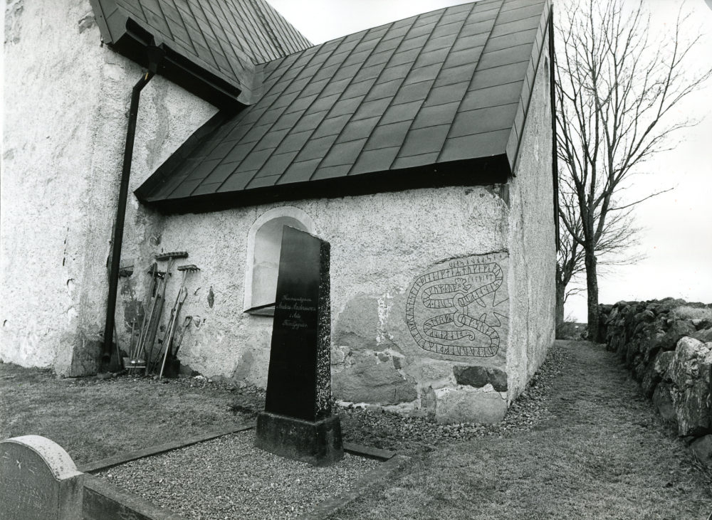 Runsten med beteckningen U201 inmurad i yttermuren i Angarns kyrka  i sakristians nordöstra hörn.